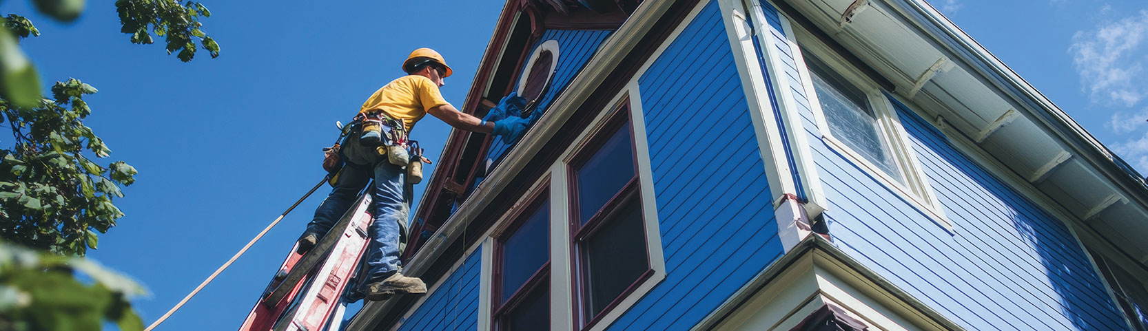 Man painting house blue